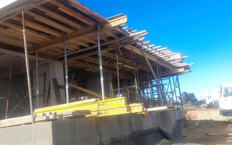 Pågående husbygge med ställningar för gjutning av betongtak
